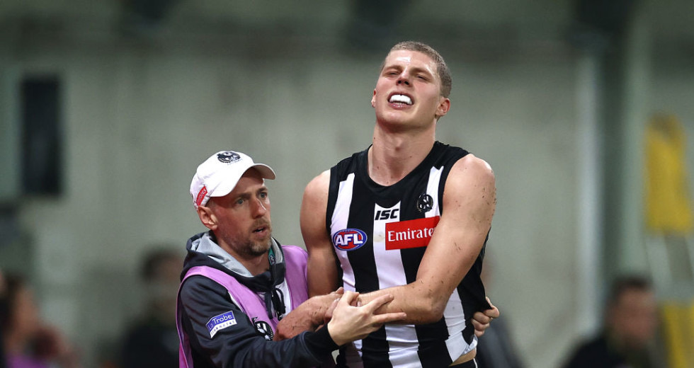 Lachlan Fooks supporting an AFL player off the field during a match