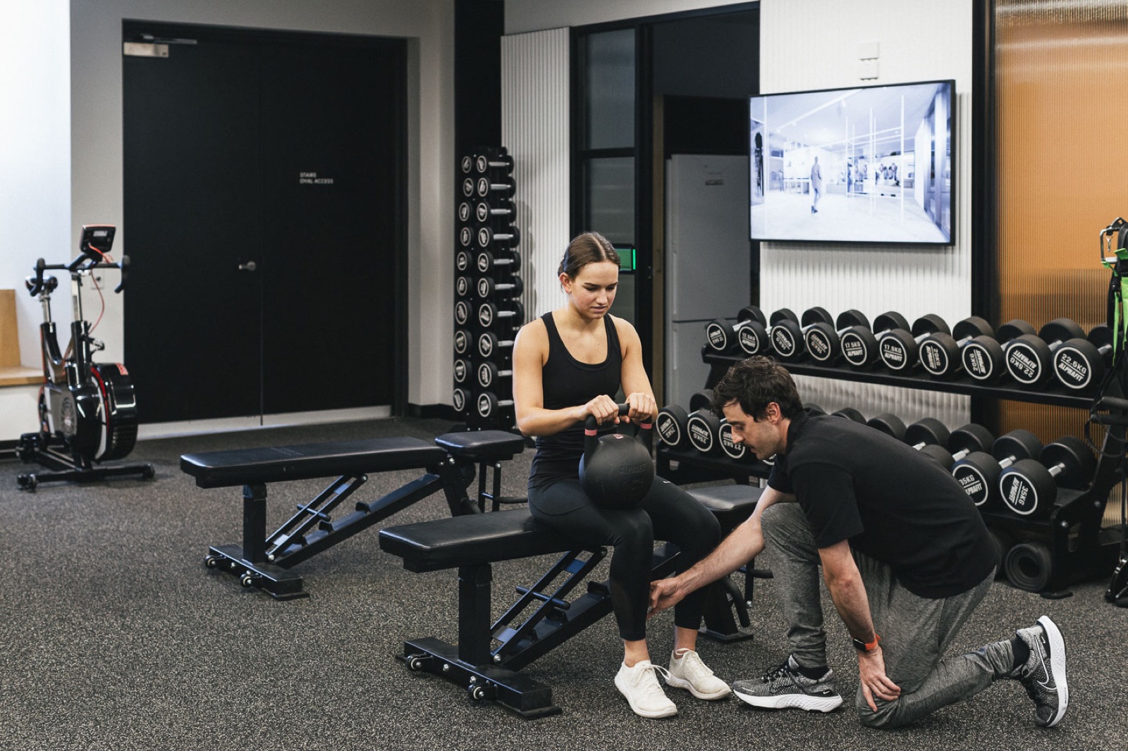 Performe clinician coaching a client through a strength session in the gym
