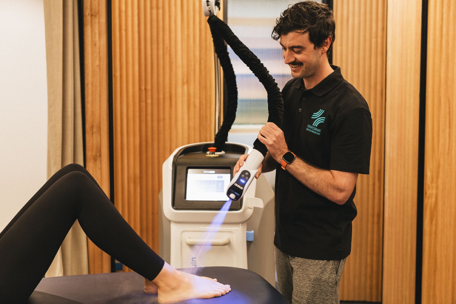 Performe clinician applying laser therapy to a patient's foot