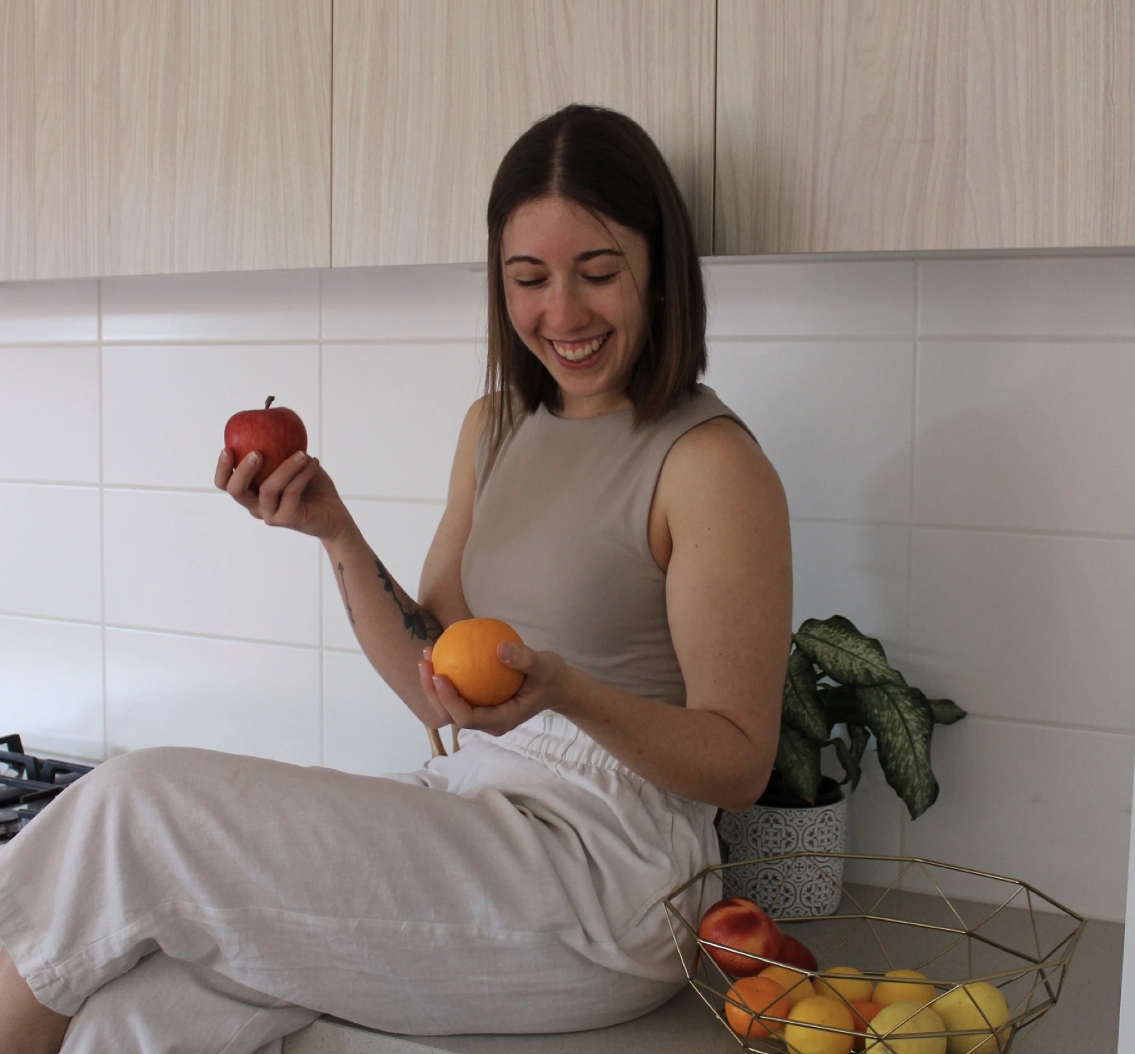 Performe sports dietitian Steph Papalaskaris holding fresh fruit in a kitchen