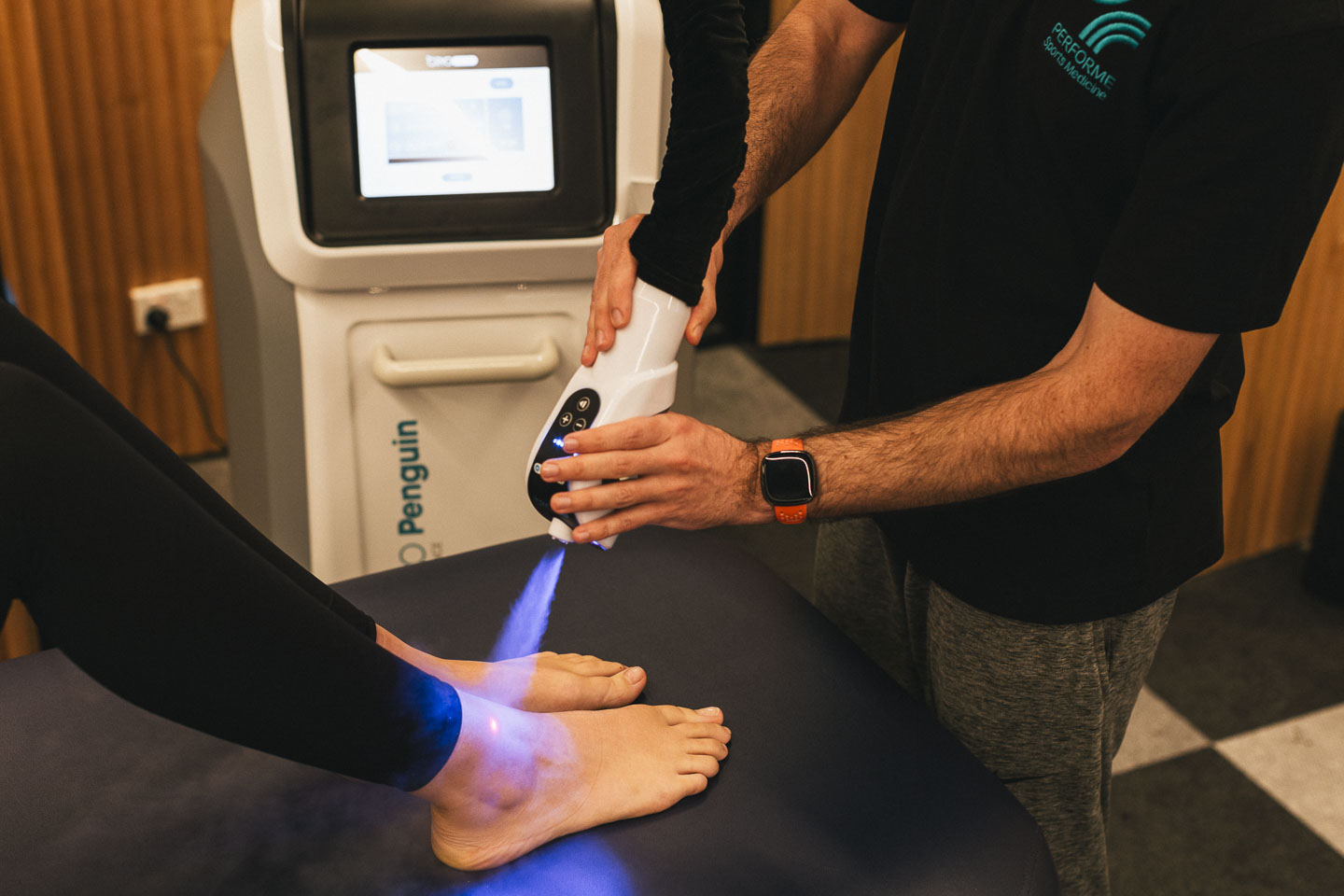 Close-up of laser therapy being applied to a patient's ankle